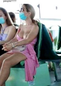 Woman with one boob out on bus wearing face mask.